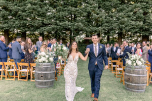 Couple recessing out of Trentadue Winery ceremony against the redwood trees